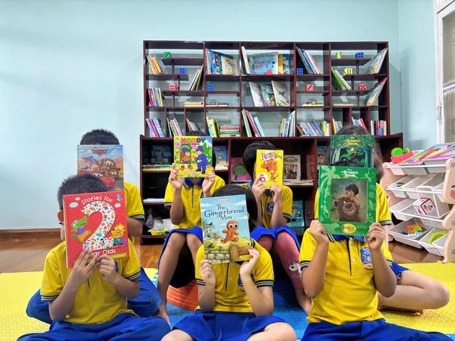 Guru children exploring picture books together in the library