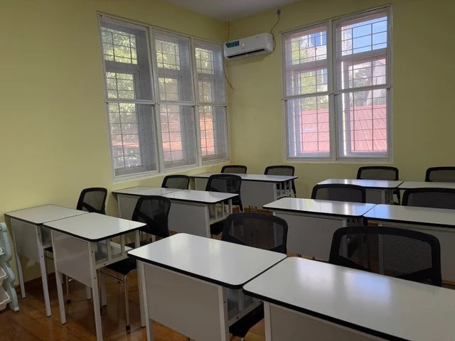 Primary classroom with individual desks and bright windows
